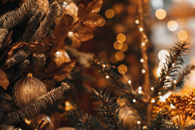 Winter holiday composition. golden christmas ball and shiny garland hanging on the christmas tree.