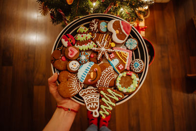 Cropped hand of person holding cookies in plate