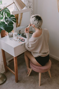 Boy sitting on table at home