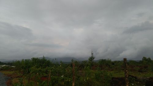 Scenic view of landscape against storm clouds