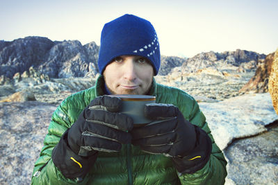 Portrait of boy standing against mountain