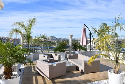 Palm trees by swimming pool against sky