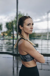 Portrait of woman standing against water