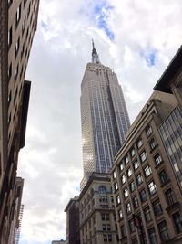 Low angle view of buildings against cloudy sky