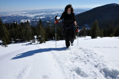 Full length of woman skiing on snow against sky