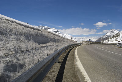 Road on snow covered mountain against sky