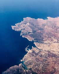 Aerial view of sea and cityscape against sky