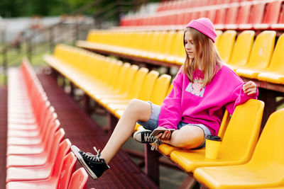 A charming girl is sitting on the school podium during a break