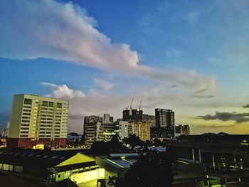 Buildings in city against sky at sunset