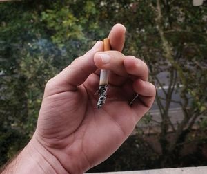 Close-up of person hand holding cigarette
