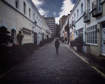 Man walking on alley amidst street