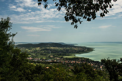 Aerial view of townscape by sea against sky