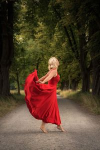 Rear view of woman standing in forest