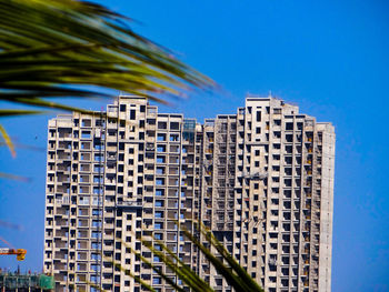 Low angle view of modern building against blue sky