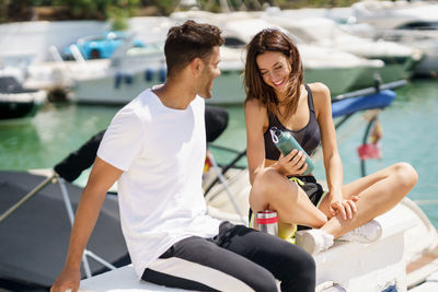 Smiling couple siting on boat at harbor