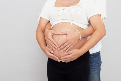 Midsection of woman standing against white background