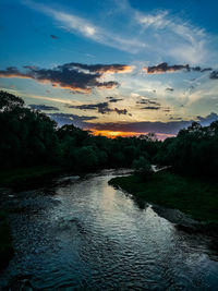 Scenic view of river against sky at sunset