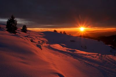 Scenic view of snowcapped mountains against sky during sunset