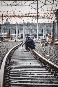 Man cycling on railroad tracks