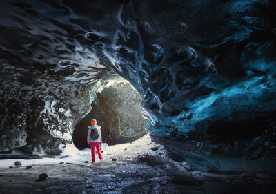 Rear view of man standing in cave