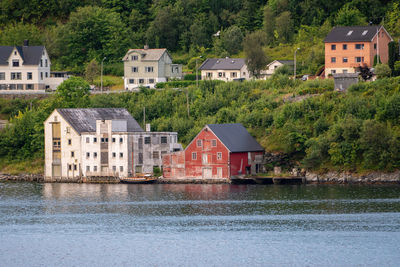 Houses by river and buildings in city