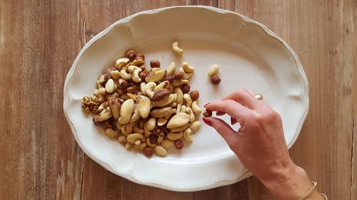 High angle view of hand holding bowl on table