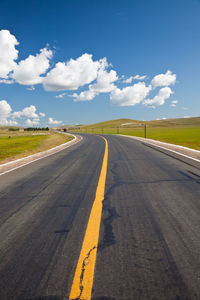 Empty road along countryside landscape