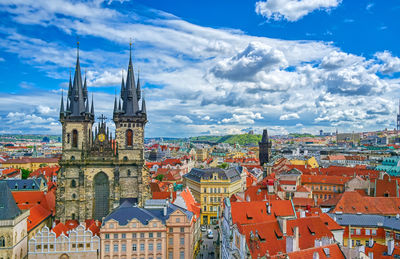 Buildings in city against cloudy sky