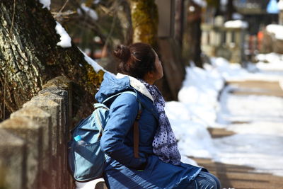 Woman sitting outdoors during winter