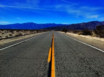 Empty road leading towards mountains