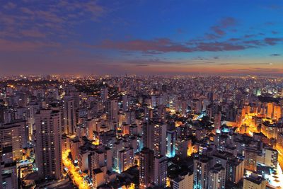 High angle view of illuminated city buildings against sky