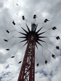 Low angle view of ferris wheel against cloudy sky