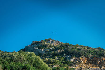 Low angle view of mountain against blue sky