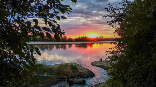 Scenic view of lake against sky at sunset