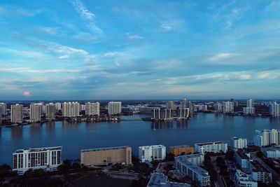 Modern buildings by sea against sky