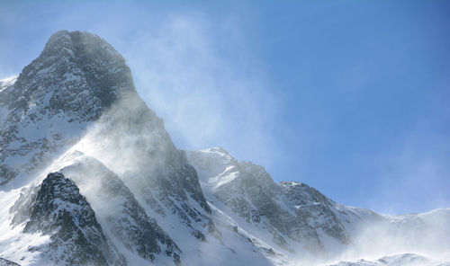 Low angle view of snowcapped mountains against sky