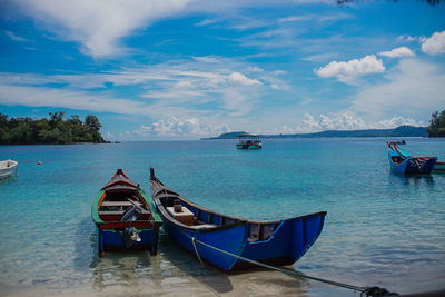 Boats moored in sea against sky