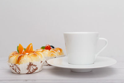Close-up of coffee cup on table against white background