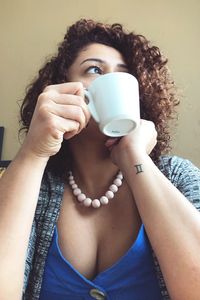 Woman with coffee cup looking away