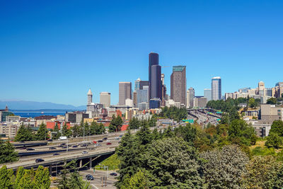 Buildings in city against clear blue sky