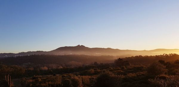 Scenic view of mountains against clear sky during sunset