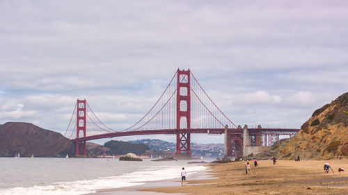 View of suspension bridge against cloudy sky