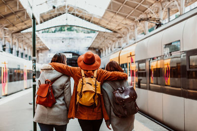 Rear view of people standing on train at railroad station