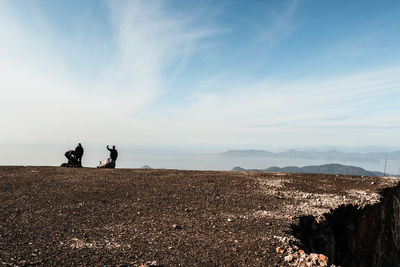 People on mountain against sky