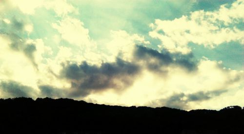 Low angle view of silhouette trees against sky