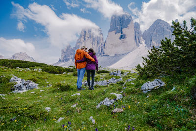 Rear view of people on mountains against sky