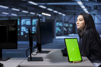 Portrait of young woman using laptop in office