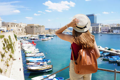 Rear view of woman standing on boat in sea