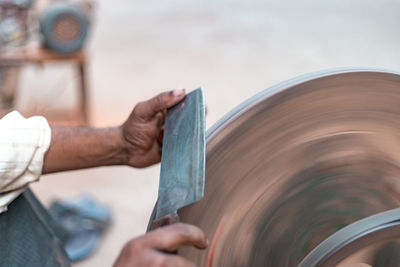 Cropped image of man sharpening knife