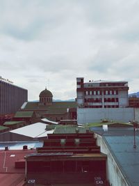 Buildings in city against cloudy sky